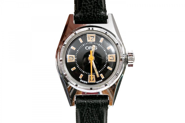 Vintage steel watch. This striking diminutive vintage 22mm watch by Oris has a retro black dial, orange hand, hand wound mechanical movement